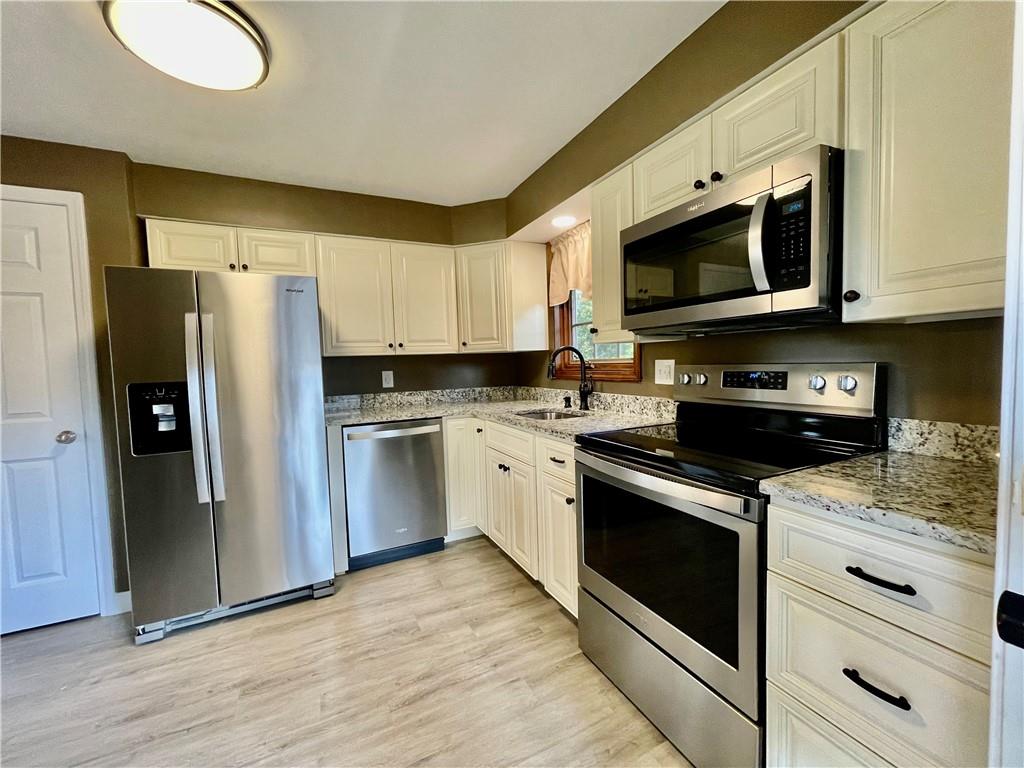 115 Bell Court Road McKees Rocks, PA 15136 - Photo 9 of 19 a kitchen with stainless steel appliances granite countertop a stove a microwave and a refrigerator