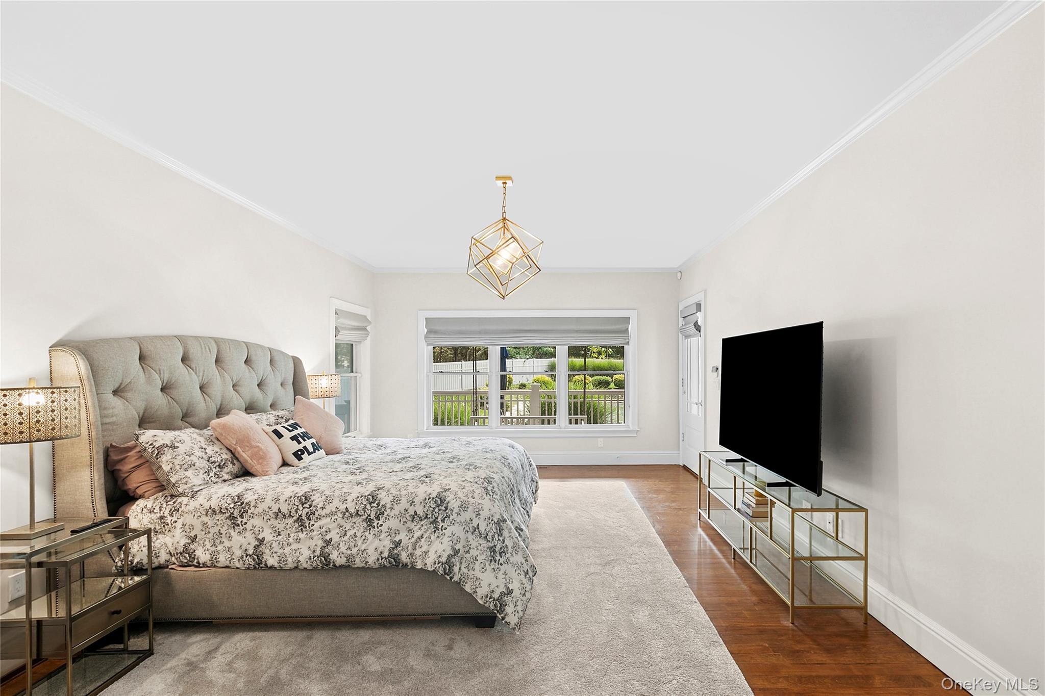 3470 North Bayview Road Southold, NY 11971 - Photo 6 of 25 Primary Bedroom en suite with ornamental molding, wood finished floors, and a chandelier with access to back deck.