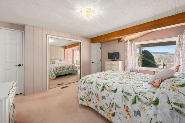 a bedroom with a bed and a large window