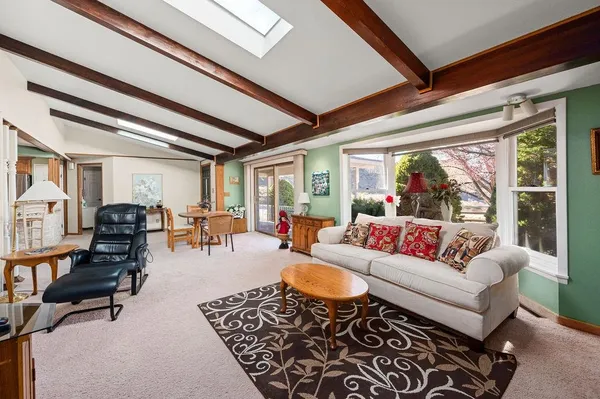 a living room with furniture potted plant and a large window