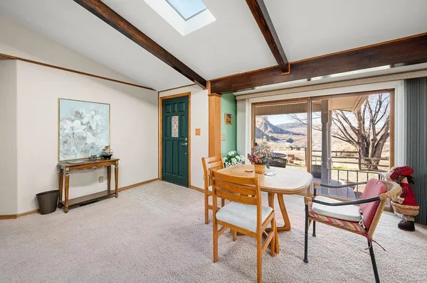 a dining room with furniture and a floor to ceiling window