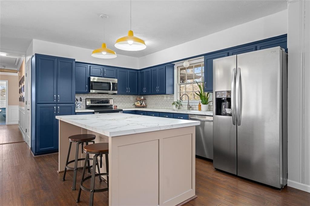 1436 Willivee Drive Decatur, GA 30033 - Photo 6 of 49 a kitchen with kitchen island granite countertop wooden cabinets a refrigerator a sink and a stove with wooden floor