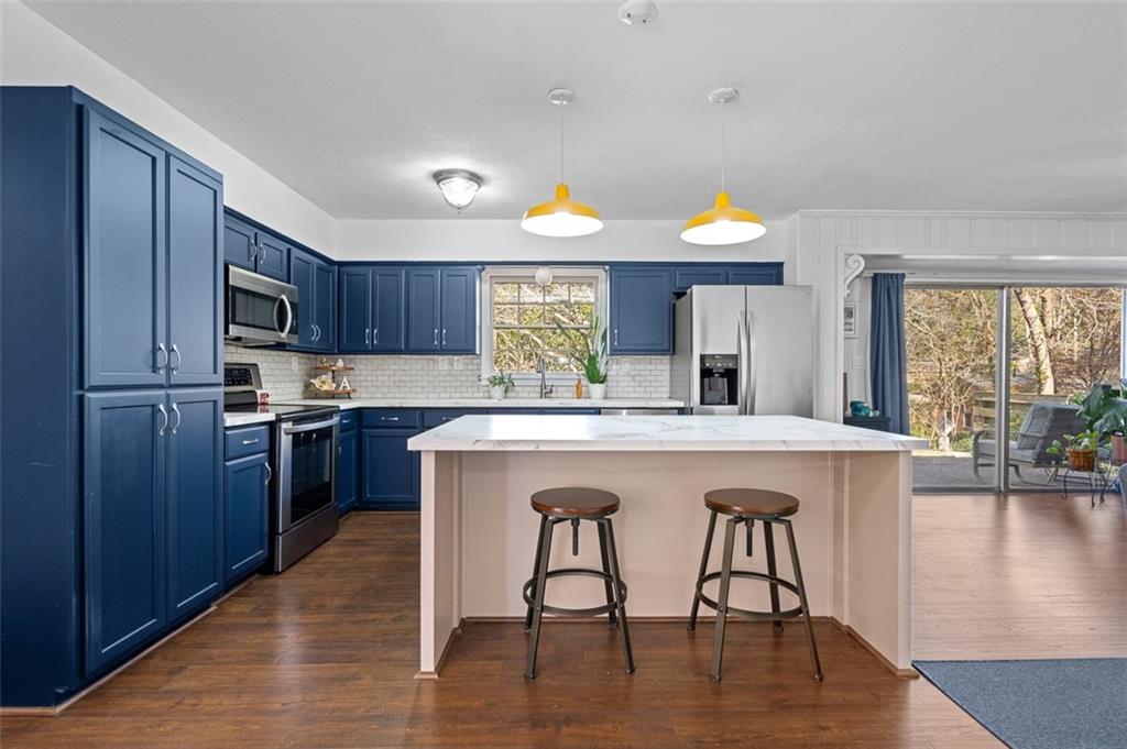 1436 Willivee Drive Decatur, GA 30033 - Photo 7 of 49 a kitchen with kitchen island granite countertop wooden floors and wooden cabinets