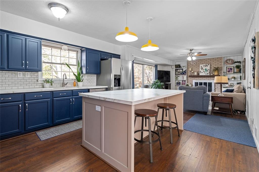 1436 Willivee Drive Decatur, GA 30033 - Photo 8 of 49 a kitchen with stainless steel appliances kitchen island granite countertop wooden floors and a view of living room