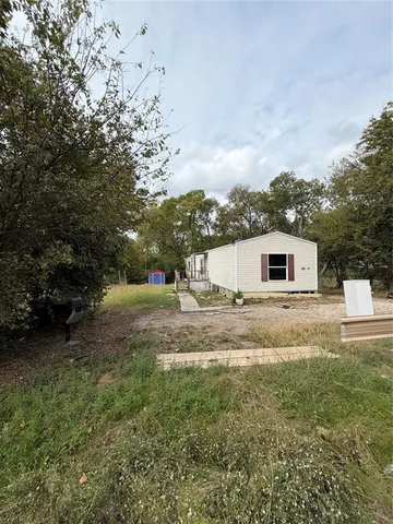 a view of a yard with a house and a tree