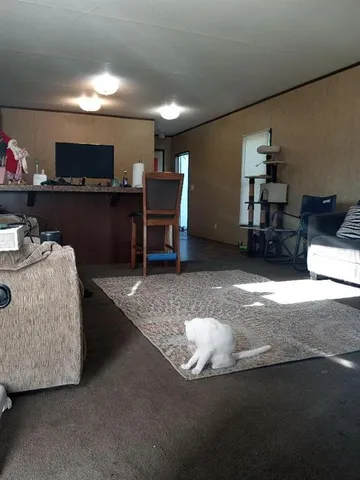 a living room with furniture a piano and a flat screen tv
