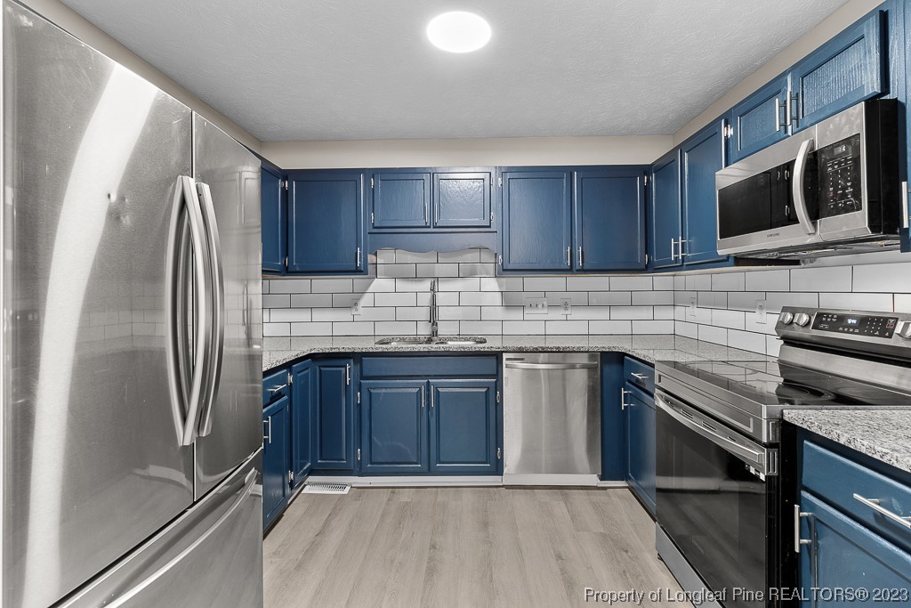 5007 Summer Ridge Road Fayetteville, NC 28303 - Photo 8 of 25 a kitchen with stainless steel appliances granite countertop a refrigerator microwave and sink