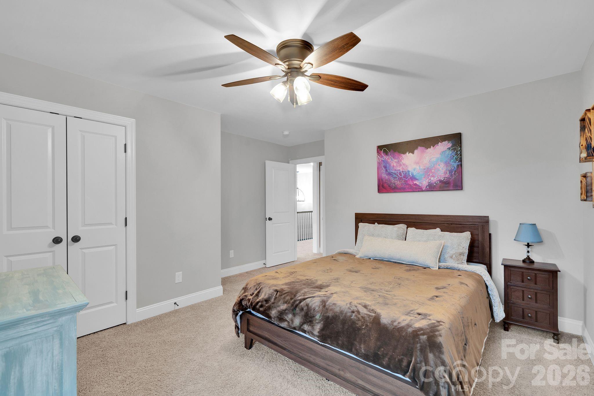 663 Highland Ridge Point Lake Wylie, SC 29710 - Photo 33 of 42 a bedroom with a bed and a chandelier