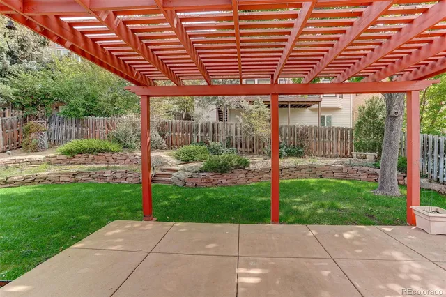 a backyard of a house with a garden and outdoor seating