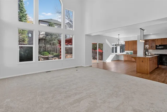 a kitchen with stainless steel appliances granite countertop a sink dishwasher and a refrigerator with wooden floor