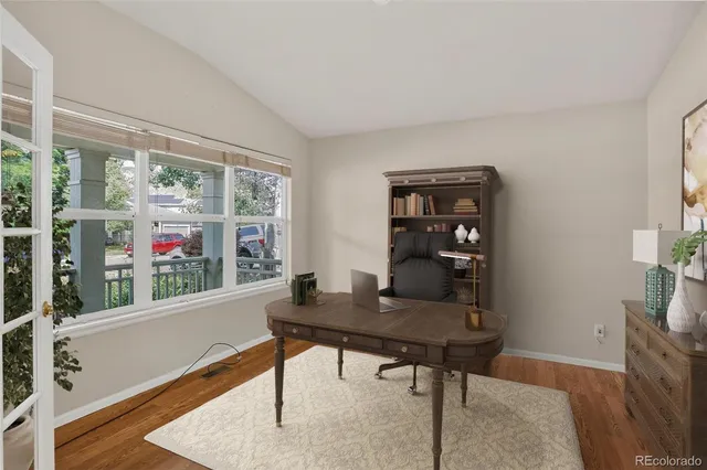 a view of a workspace with furniture and a window