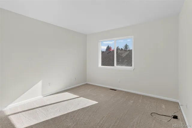 a spacious bathroom with a granite countertop sink a toilet a mirror and shower