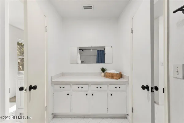 a kitchen with stainless steel appliances a refrigerator a sink a stove and white cabinets