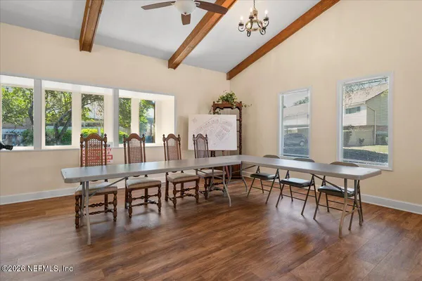 a room with a table chairs and a window