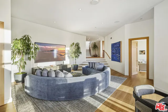 a living room with furniture and a floor to ceiling window