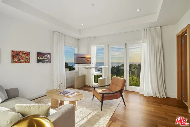 a living room with furniture a chandelier and a large window