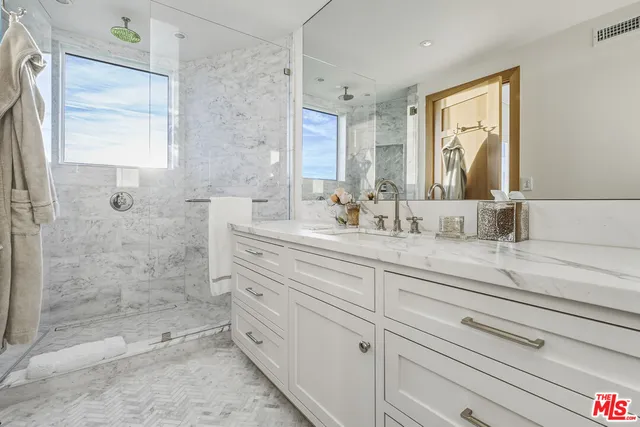 a spacious bathroom with double vanity and a mirror