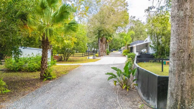 a view of a house with a outdoor space and large trees