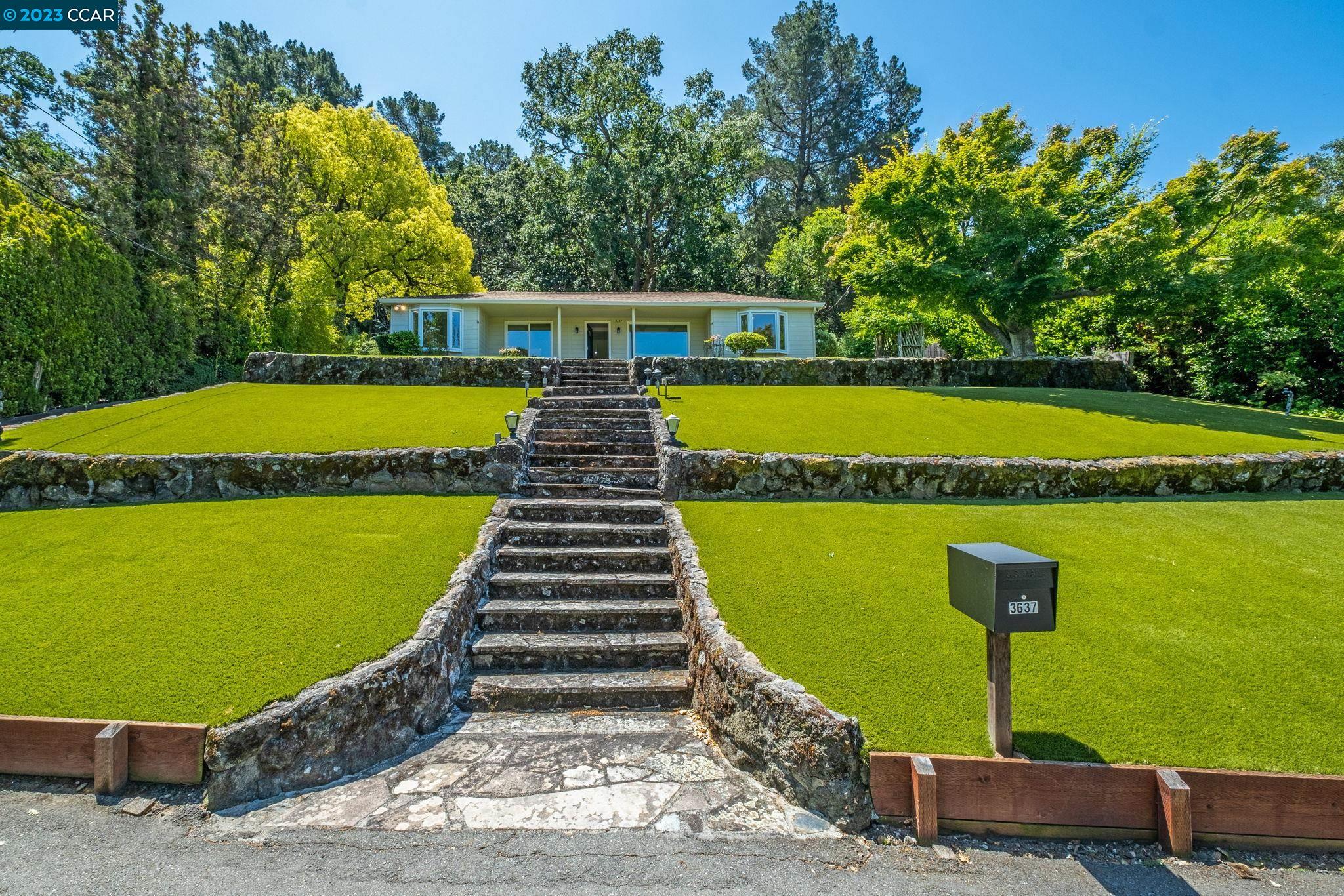 a view of swimming pool with seating area and trees in the background