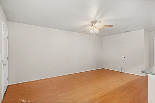an empty room with a window and a ceiling fan
