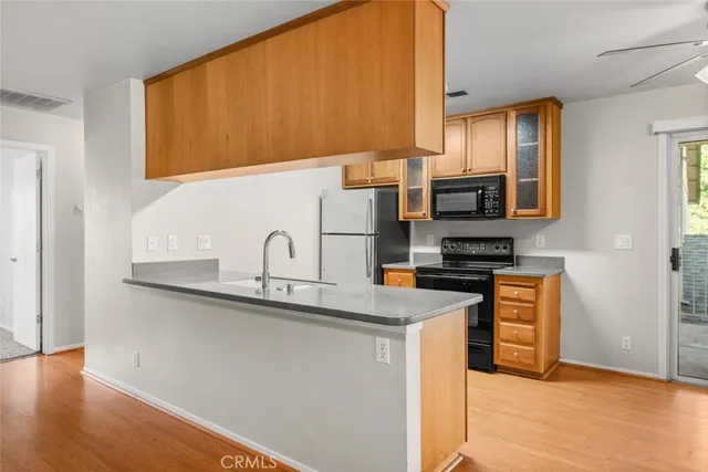 a kitchen with stainless steel appliances granite countertop a sink a stove and a refrigerator