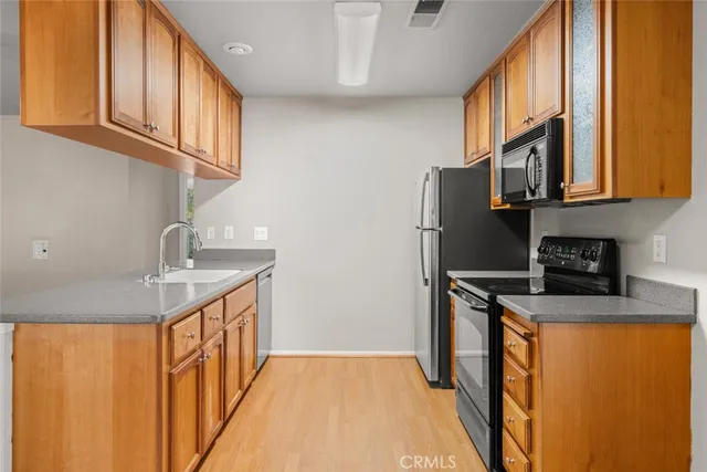 a kitchen with stainless steel appliances granite countertop a refrigerator a sink and a stove