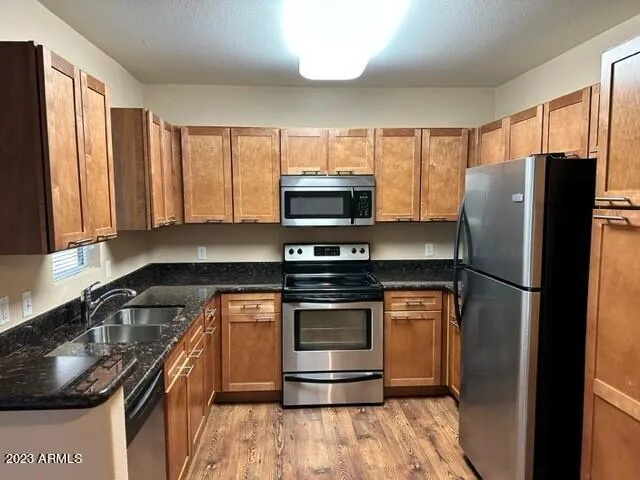 a kitchen with a stove a refrigerator and a sink