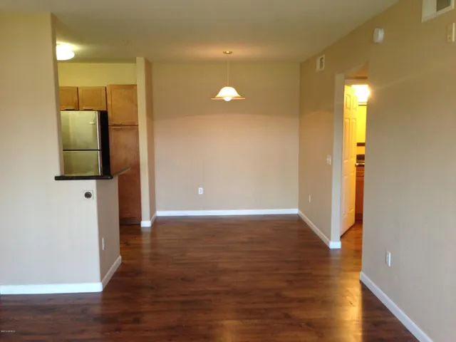 a view of a hallway with wooden floor and a bathroom