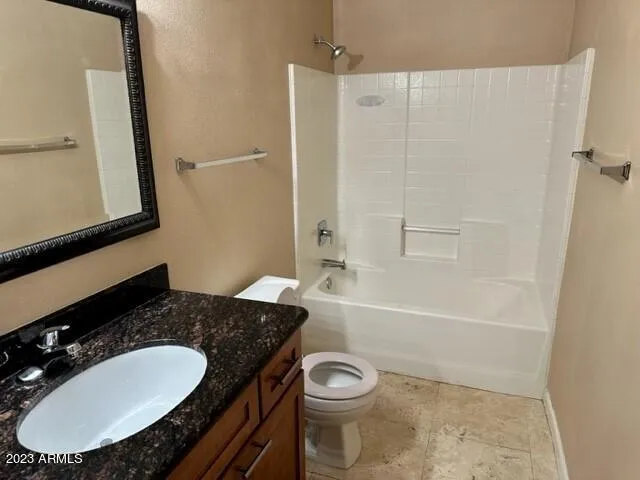 a bathroom with a granite countertop sink toilet a mirror and bathtub