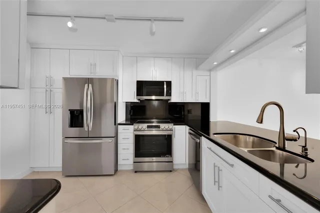a kitchen with stainless steel appliances a refrigerator sink and microwave