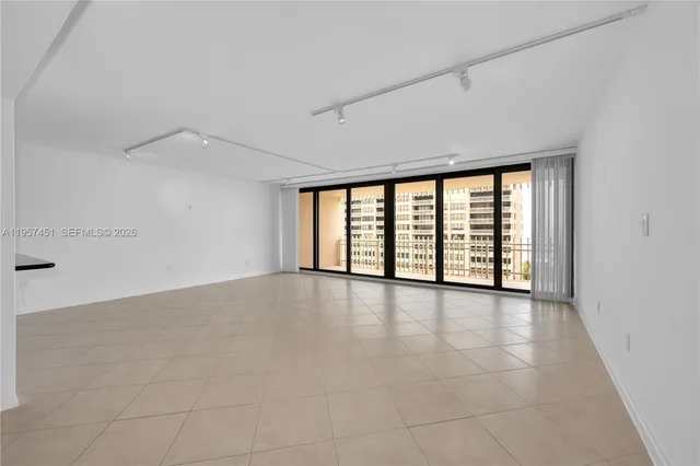 an empty room with windows and city view