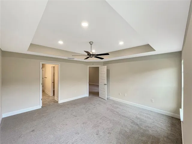 an empty room with fan and windows