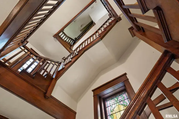 a view of staircase with railing and white walls
