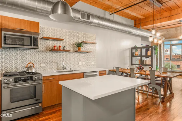 a kitchen with stainless steel appliances a stove a sink a stove and white cabinets