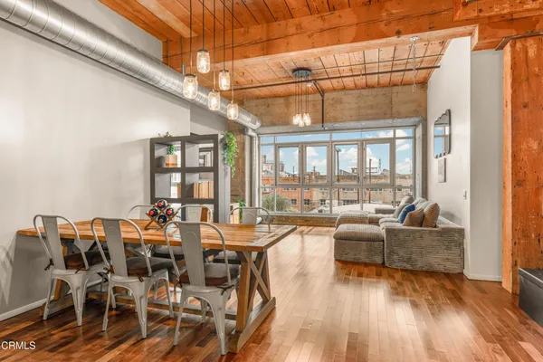 a view of a dining room with furniture wooden floor and windows
