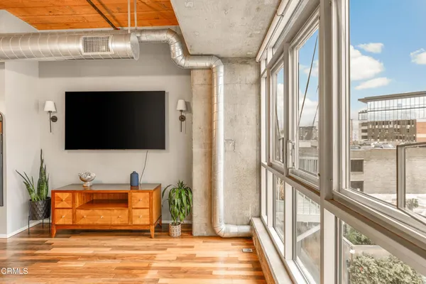 a living room with a flat screen tv and a floor to ceiling window
