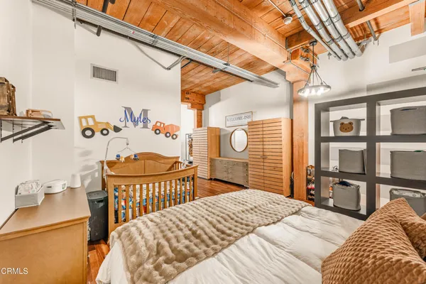 a bedroom with a bed a table and book shelf