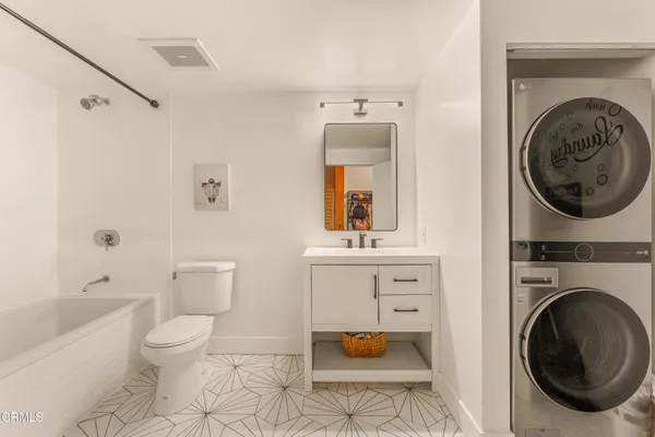 a spacious bathroom with a toilet a sink and a mirror