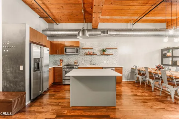 a kitchen with stainless steel appliances a stove top oven a sink and cabinets
