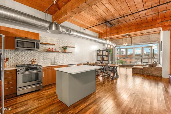 a kitchen with stainless steel appliances and wooden floor