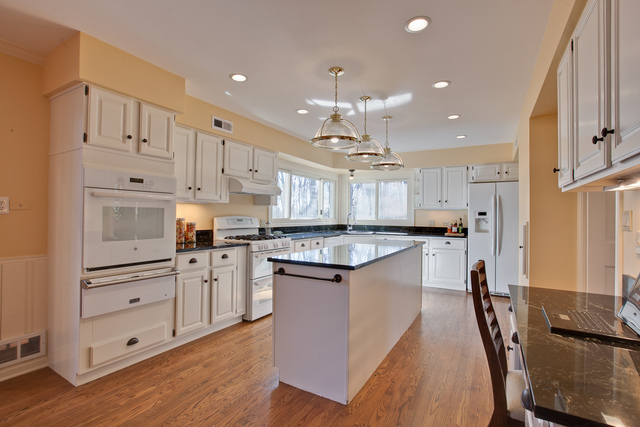 721 Rockefeller Road Lake Forest, IL 60045 - Photo 13 of 25 a kitchen with stainless steel appliances kitchen island granite countertop a refrigerator a stove and white cabinets with wooden floors
