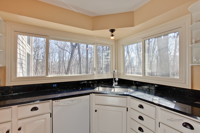 721 Rockefeller Road Lake Forest, IL 60045 - Photo 14 of 25 a kitchen with granite countertop white cabinets and black appliances