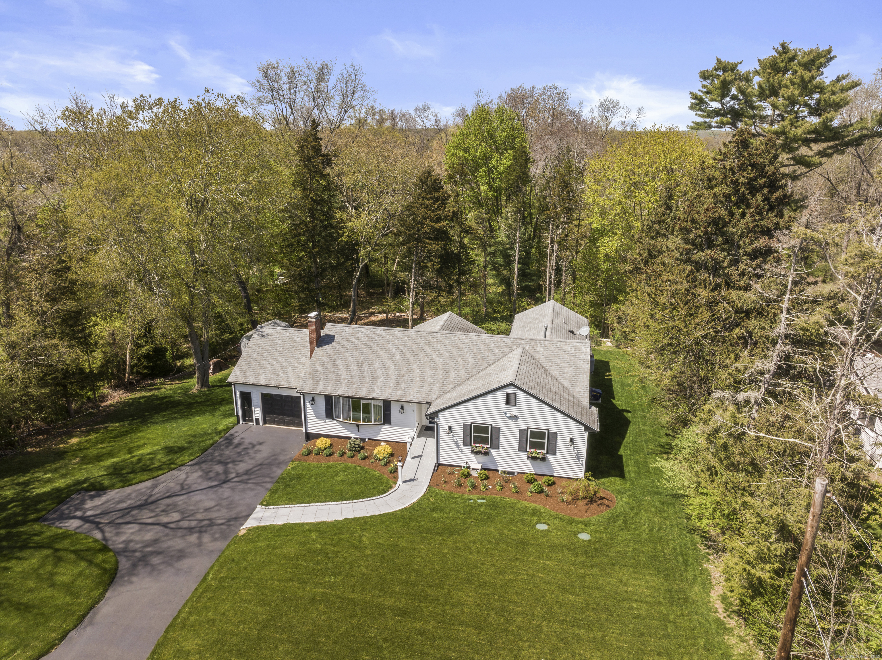 aerial view of a house with a big yard and large trees