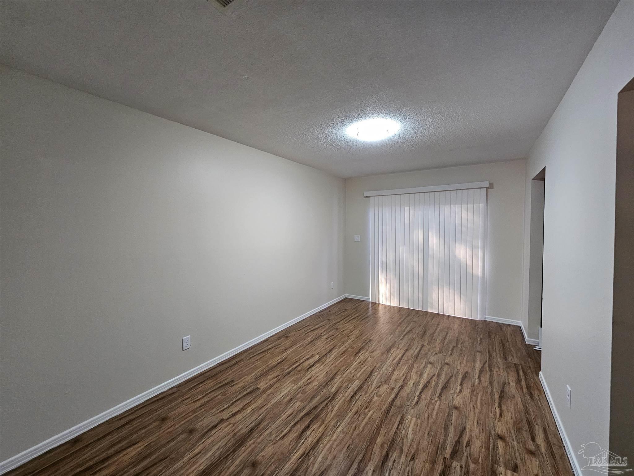 3689 East Olive Road Pensacola, FL 32514 - Photo 3 of 6 a view of empty room with wooden floor