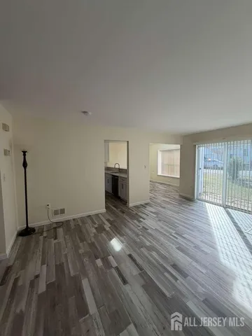 a view of empty room with wooden floor and window