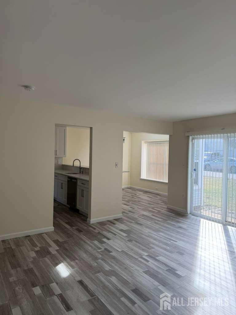 126 Winchester Way Somerset, NJ 08873 - Photo 5 of 33 a view of empty room with wooden floor and cabinet