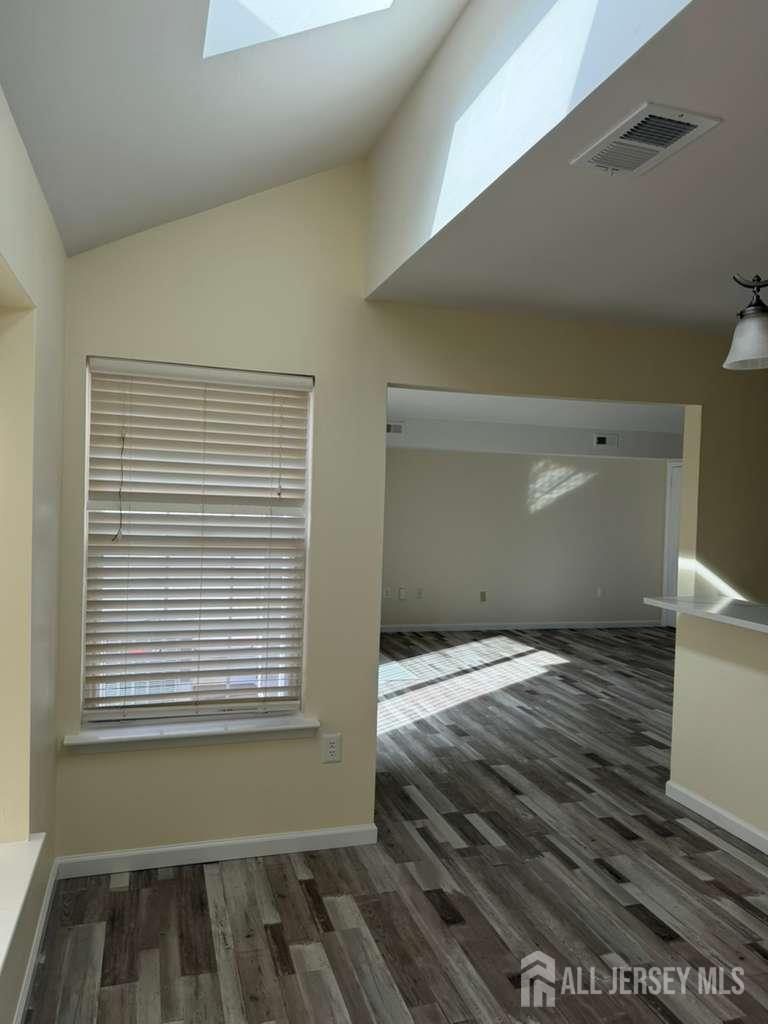 126 Winchester Way Somerset, NJ 08873 - Photo 7 of 33 a view of an empty room with wooden floor and a window