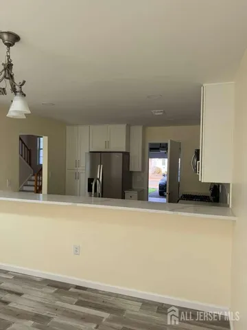 a view of a kitchen with a sink and a refrigerator