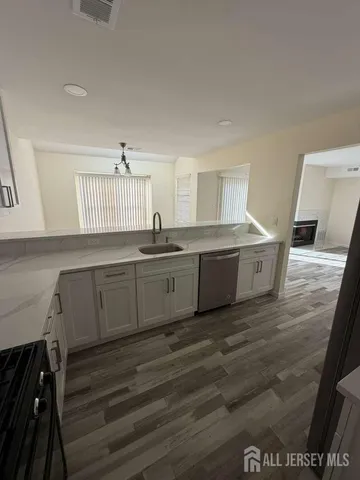 a kitchen with a sink cabinets and wooden floor