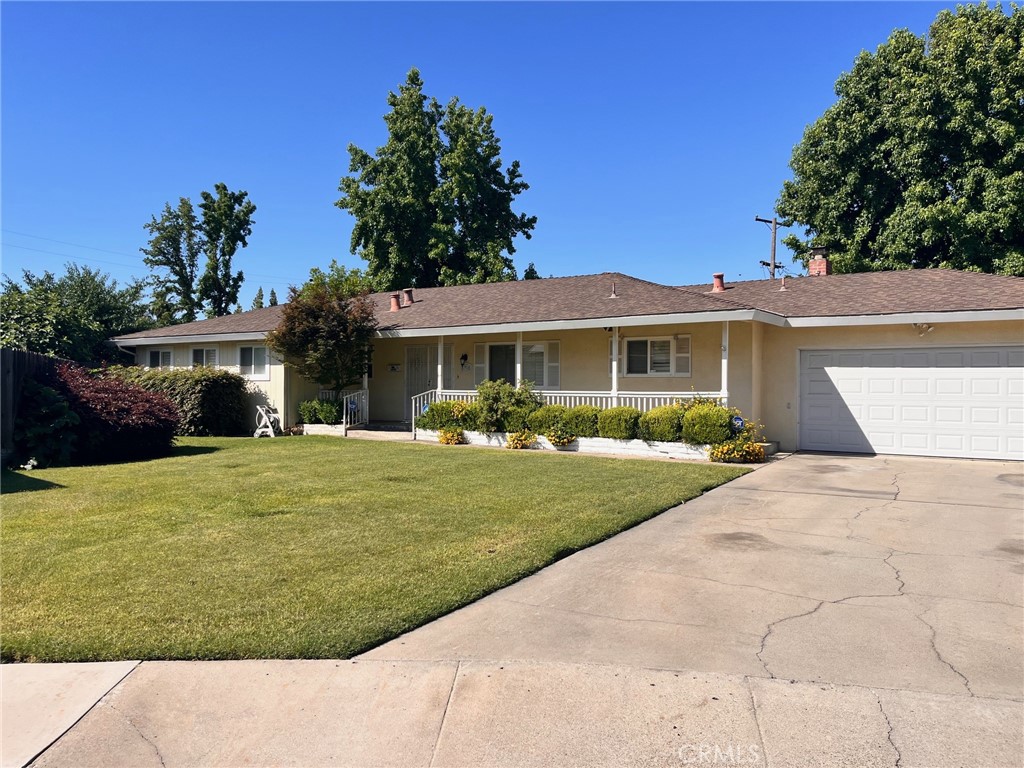 a front view of a house with a yard and potted plants